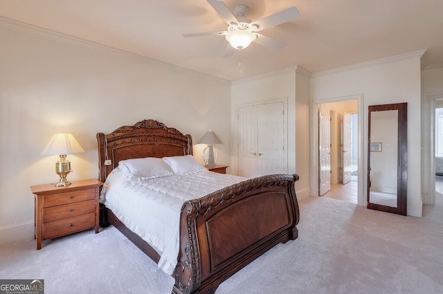 carpeted bedroom featuring ceiling fan, a closet, and ornamental molding