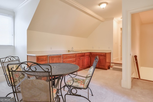 dining space with sink, light colored carpet, ornamental molding, and vaulted ceiling