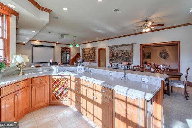 kitchen featuring kitchen peninsula, light tile patterned floors, ceiling fan, and crown molding