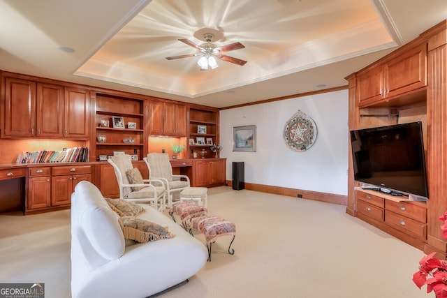 carpeted living room with crown molding, built in features, ceiling fan, and a raised ceiling