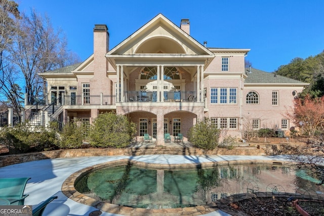 back of house featuring a balcony and a patio area