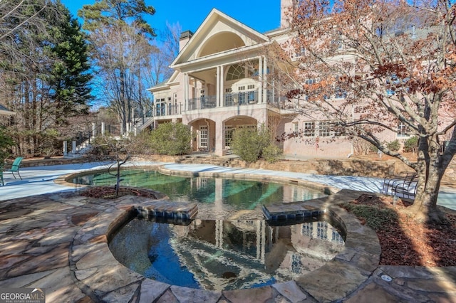 exterior space featuring a swimming pool and a patio