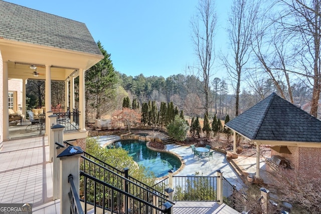 view of swimming pool featuring ceiling fan and a patio