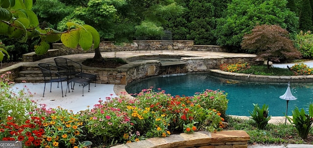 view of swimming pool with an in ground hot tub and a patio area