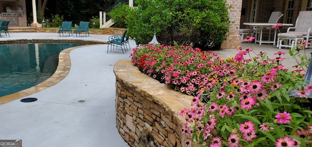 view of property's community with a patio, an outdoor kitchen, and a swimming pool