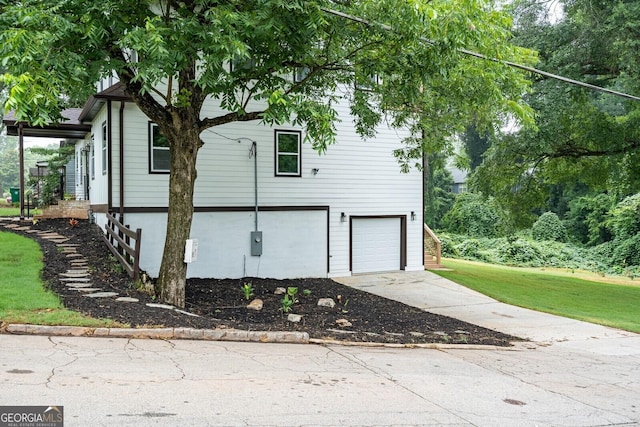 view of home's exterior featuring a garage and a lawn