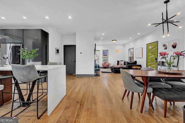 dining area with an inviting chandelier and light wood-type flooring