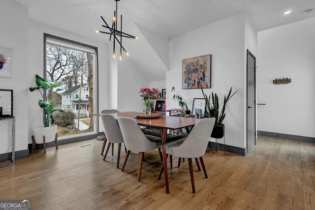 dining area with a chandelier and light hardwood / wood-style flooring