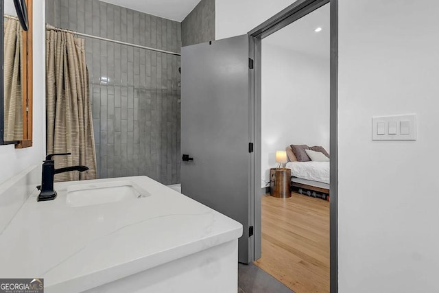 bathroom with a shower with curtain, wood-type flooring, and vanity