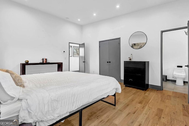 bedroom featuring ensuite bathroom and light hardwood / wood-style flooring