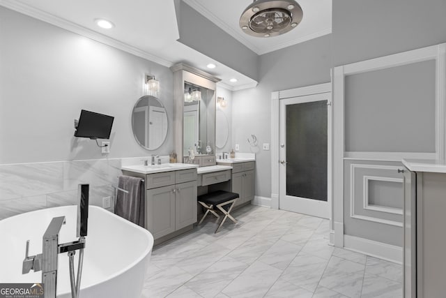 bathroom featuring a tub to relax in, vanity, and ornamental molding