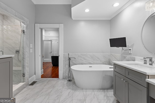 bathroom featuring vanity, independent shower and bath, ornamental molding, and tile walls