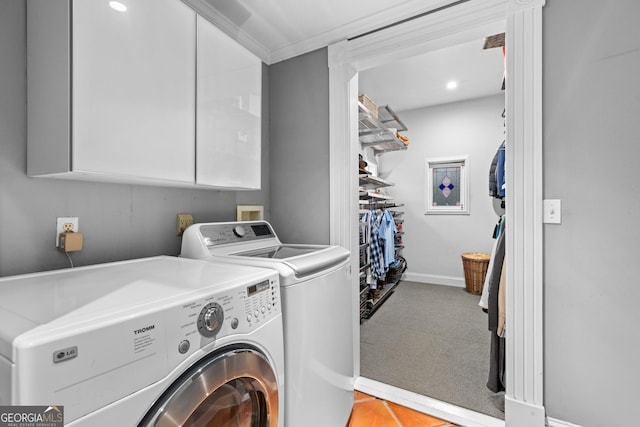 laundry room featuring washer and dryer, cabinets, and crown molding