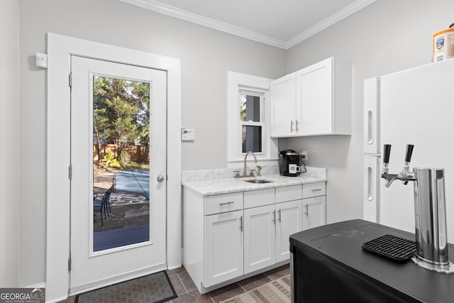 kitchen with sink, white cabinetry, crown molding, and white fridge