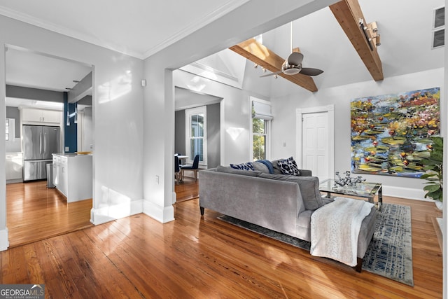 living room featuring hardwood / wood-style flooring, vaulted ceiling with beams, and ceiling fan