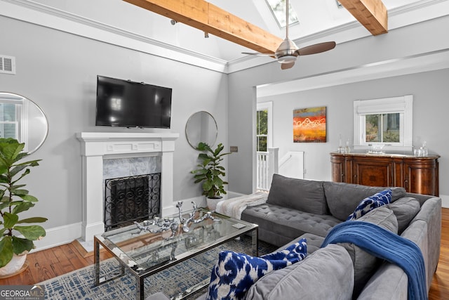 living room with wood-type flooring, a high end fireplace, and lofted ceiling with skylight