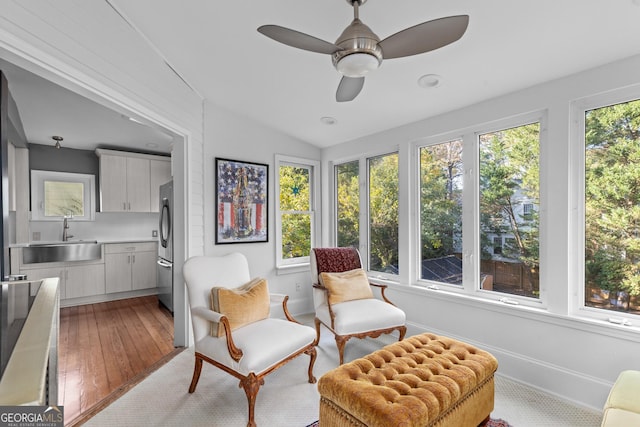 living area with sink, a healthy amount of sunlight, vaulted ceiling, and ceiling fan