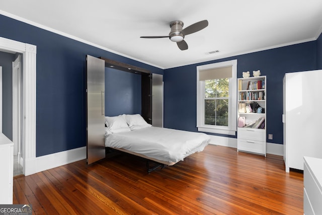 bedroom with ceiling fan, dark hardwood / wood-style floors, and ornamental molding