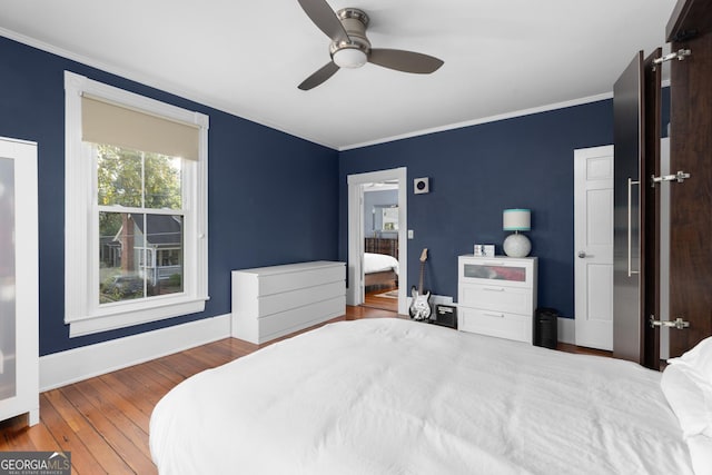 bedroom featuring ceiling fan, hardwood / wood-style floors, and ornamental molding