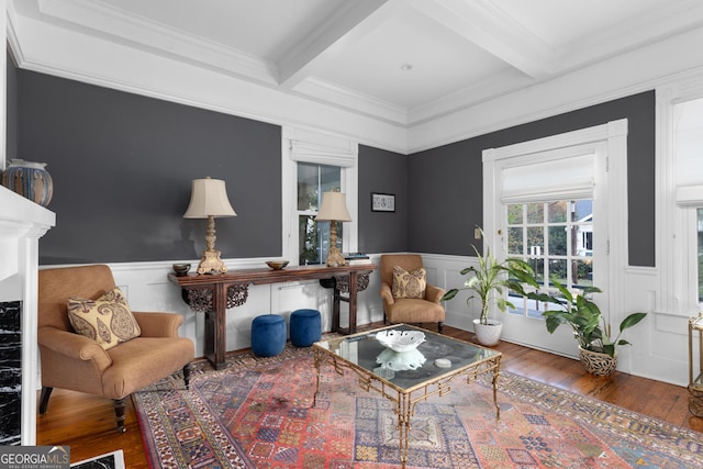 living area featuring hardwood / wood-style floors, ornamental molding, beamed ceiling, and coffered ceiling