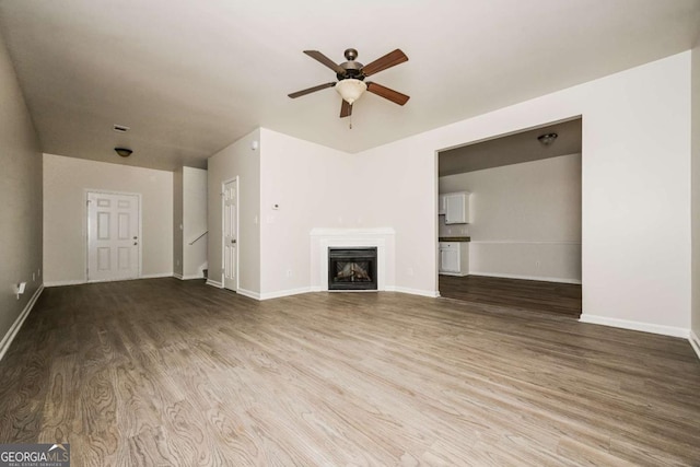 unfurnished living room with ceiling fan and wood-type flooring