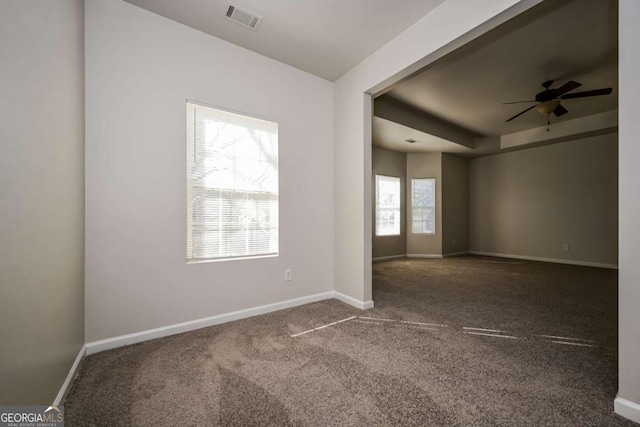 spare room featuring ceiling fan, a healthy amount of sunlight, and carpet flooring