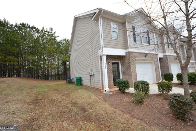 view of front of property featuring a front yard, central AC, and a garage