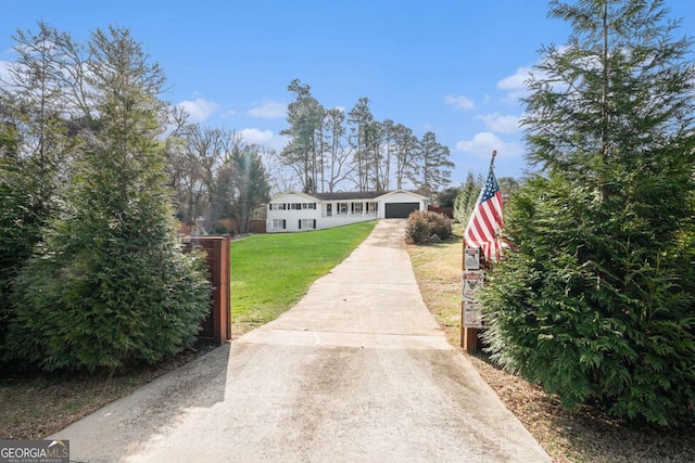 view of front of home with a front lawn, a garage, and an outbuilding