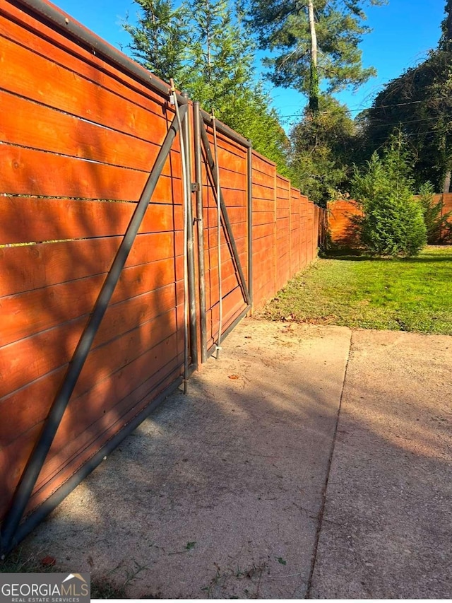 view of gate with a yard