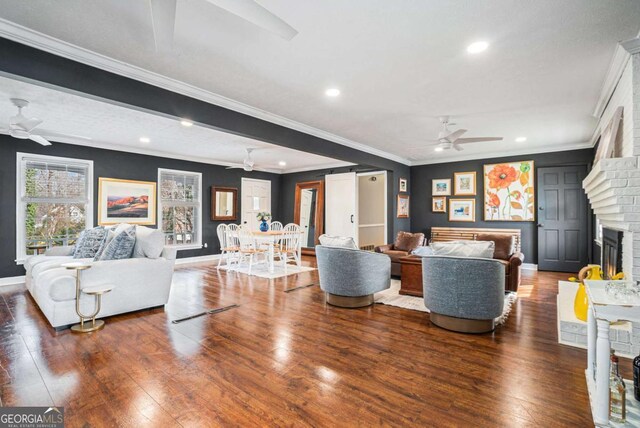 living room with a wealth of natural light, ornamental molding, and dark hardwood / wood-style floors