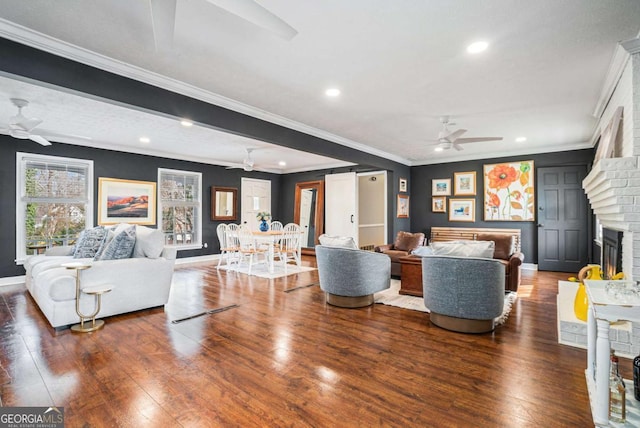 living room featuring dark wood-type flooring, a brick fireplace, and ceiling fan