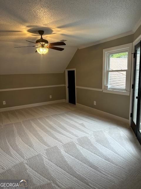 bonus room featuring light carpet, ceiling fan, vaulted ceiling, and a textured ceiling