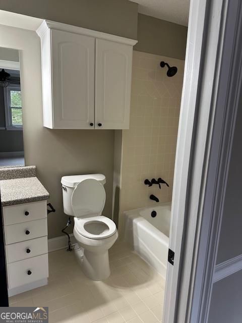 full bathroom with vanity, toilet, tiled shower / bath combo, and tile patterned flooring