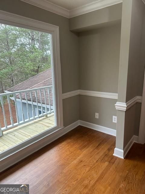 unfurnished room featuring hardwood / wood-style flooring and ornamental molding