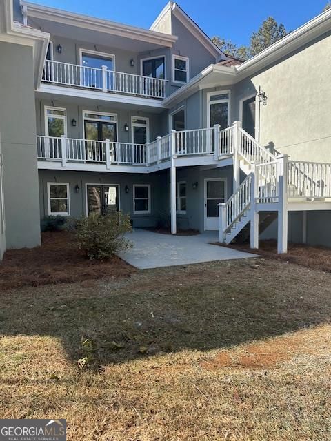 back of property with a yard and a patio area