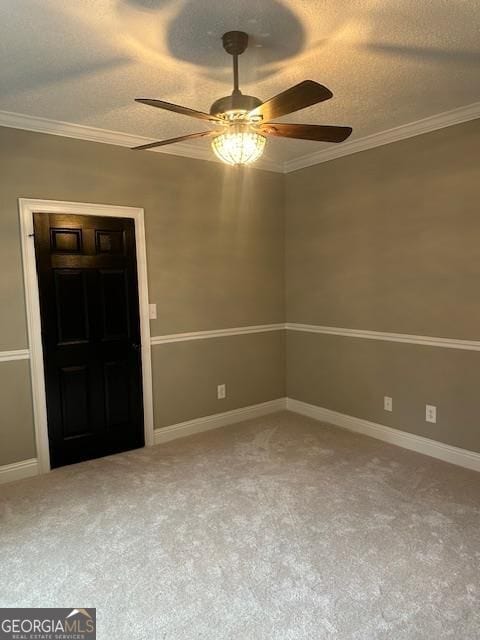 unfurnished room with ceiling fan, ornamental molding, carpet flooring, and a textured ceiling