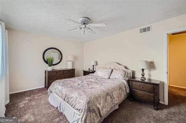 bedroom featuring dark colored carpet, a textured ceiling, and ceiling fan