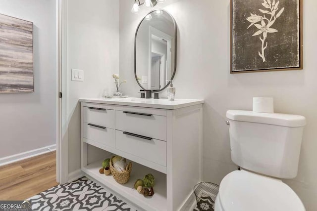 bathroom with hardwood / wood-style floors, toilet, and vanity