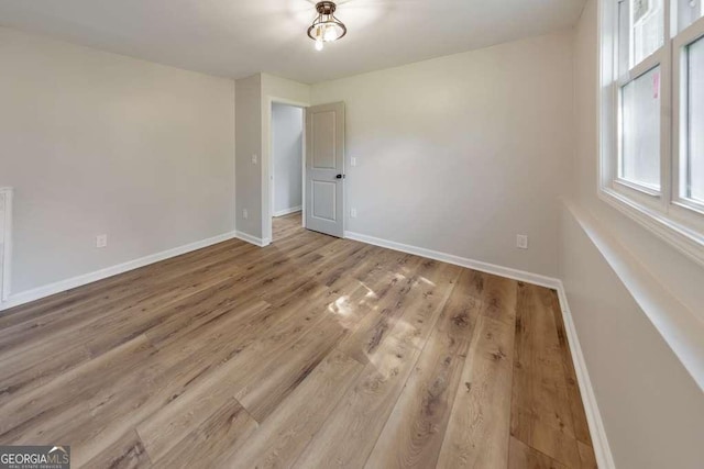 unfurnished room with hardwood / wood-style floors