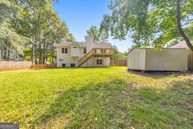 back of house with a storage unit, a deck, and a yard