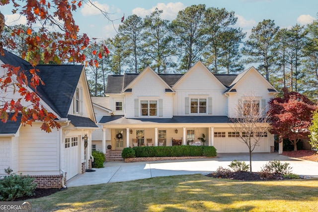 view of front facade with a garage, a front lawn, and covered porch