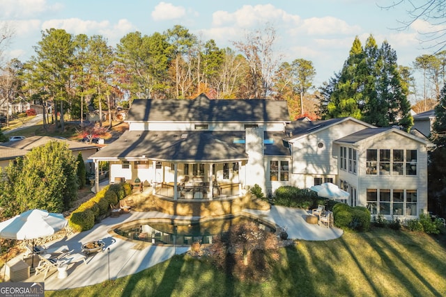 rear view of property with a patio and a yard