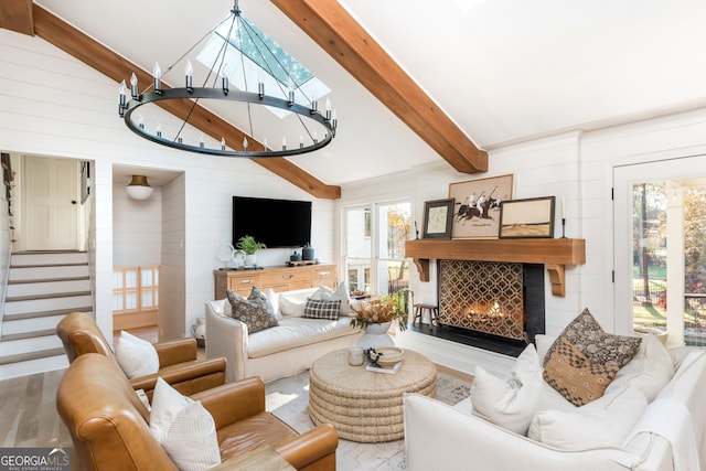 living room with wood-type flooring, vaulted ceiling with beams, and a chandelier