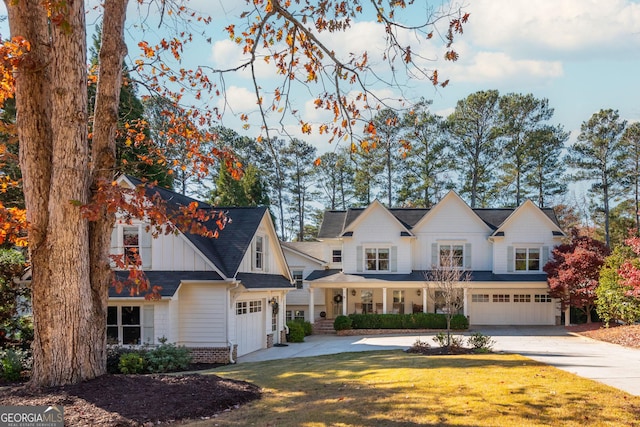 view of front facade featuring a garage, a front lawn, and covered porch