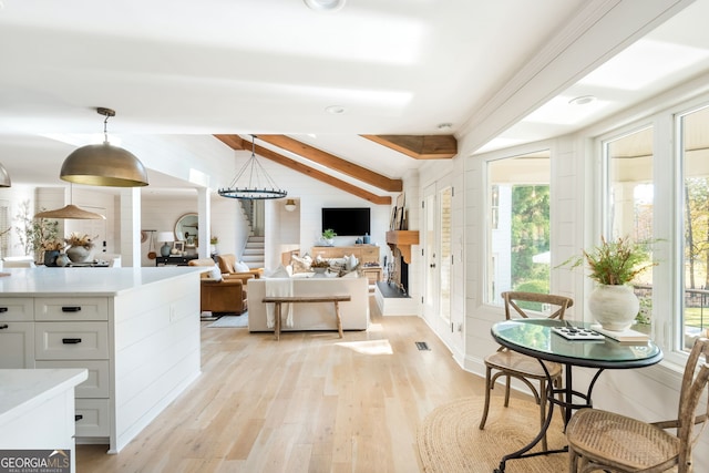 living room featuring beamed ceiling and light wood-type flooring