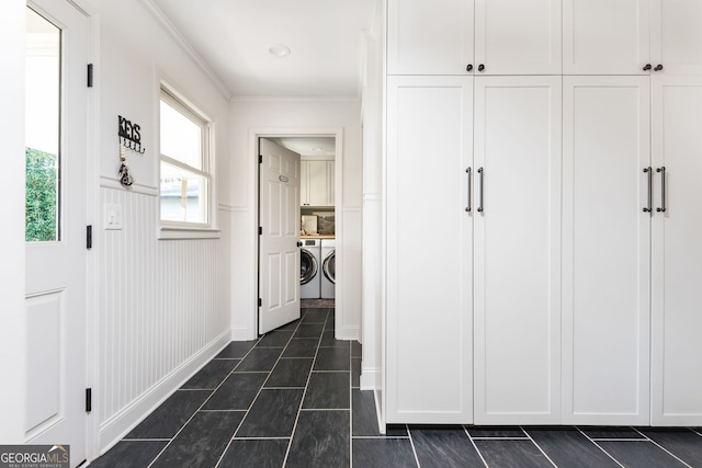 hallway featuring ornamental molding, separate washer and dryer, and dark tile patterned flooring