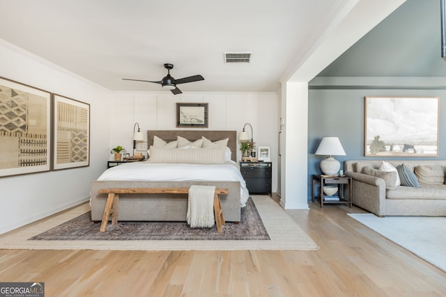 bedroom featuring ceiling fan, ornamental molding, and light wood-type flooring