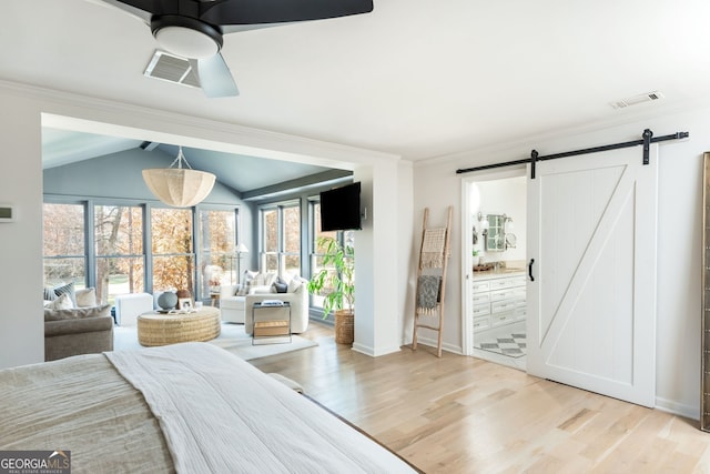 bedroom with lofted ceiling, access to exterior, ornamental molding, a barn door, and light hardwood / wood-style floors