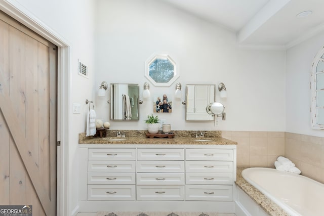 bathroom with vanity and a washtub