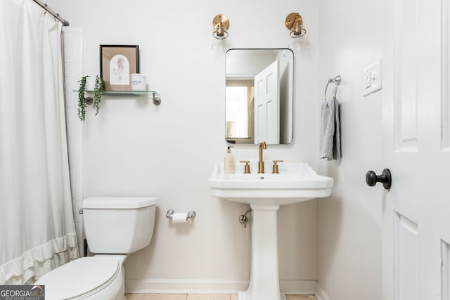 bathroom featuring toilet and curtained shower